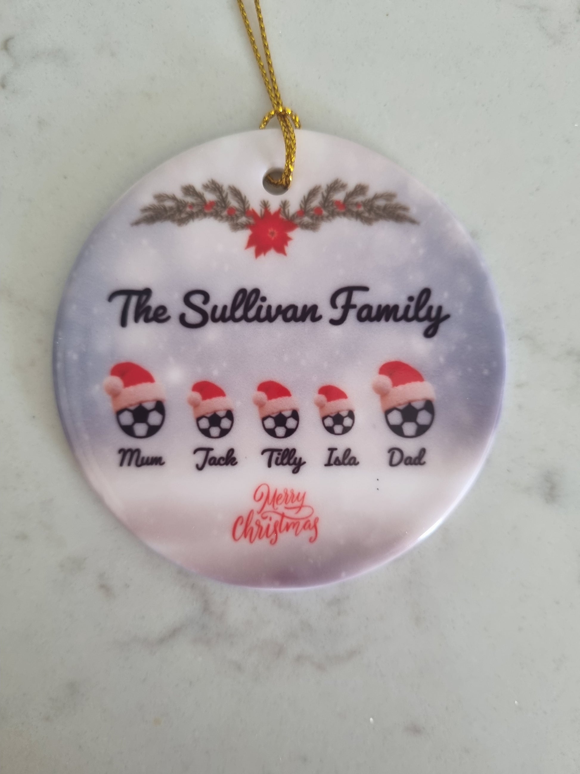 Footballs wearing santa hats on a ceramic ornament with Family names